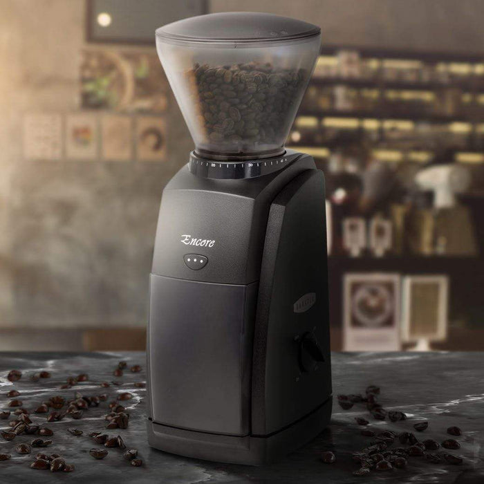 Black Baratza Encore Grinder with coffee beans filled bean hopper with coffee beans on a marble surface