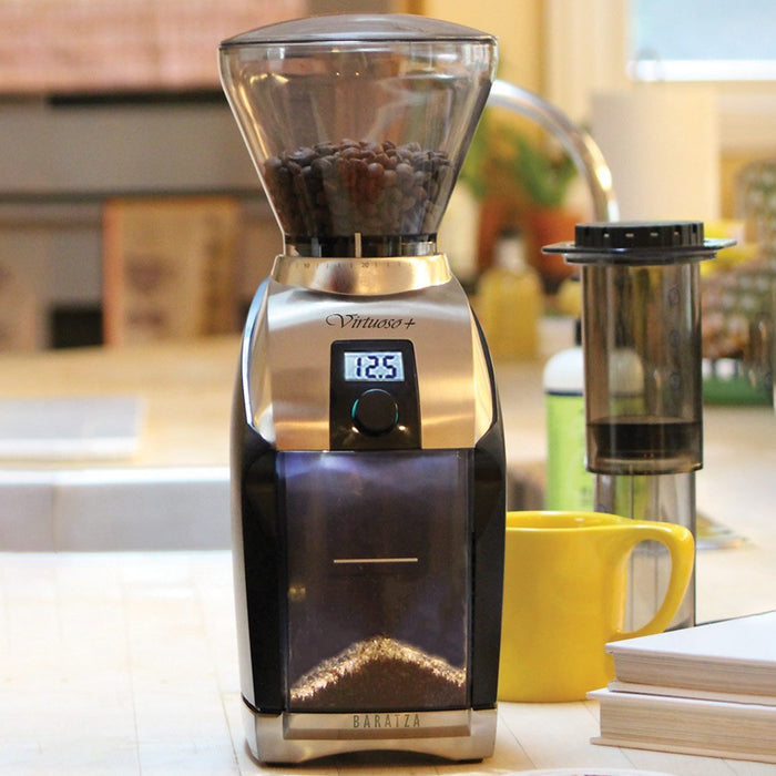 Front view of Baratza Virtuoso+ Burr Coffee Grinder with coffee beans inside bean hopper displayed in a kitchen setting