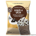 Bag of Big Train Cookies 'N Cream drink mix with a chocolate milkshake and cookies on top.