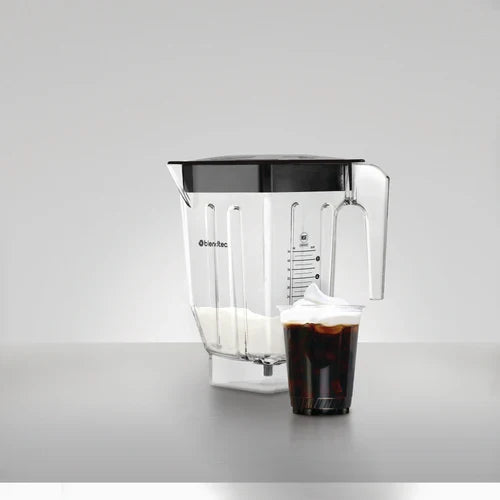 Blender container with a glass of brown liquid with foam on top on a gray background