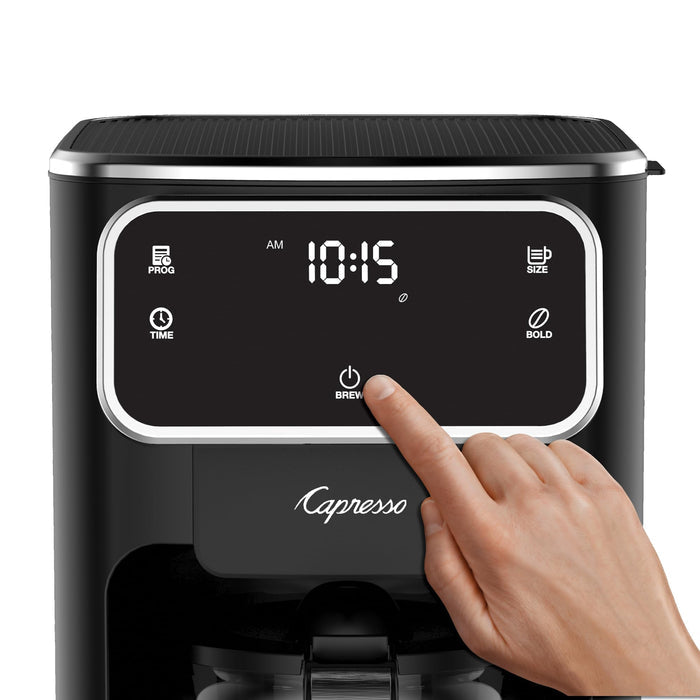 Capresso coffee machine with digital display and hand interacting with it on a white background