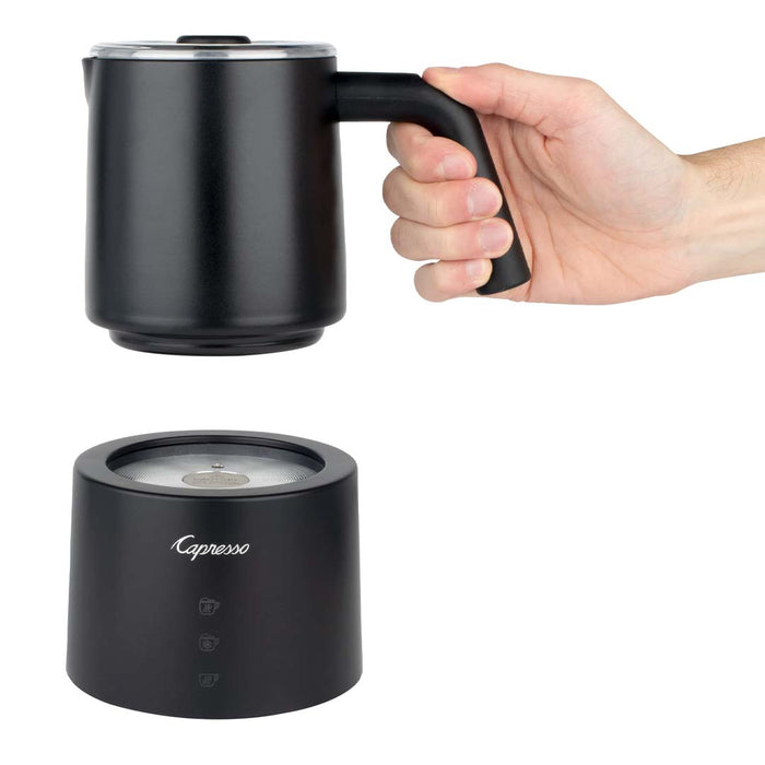 Someone holding a portion of black Capresso automatic milk frother displayed on a white background