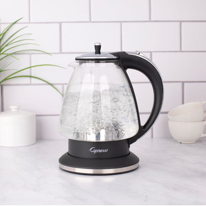 Black and polished chrome Capresso 48 oz electric kettle with water boiling on a kitchen counter