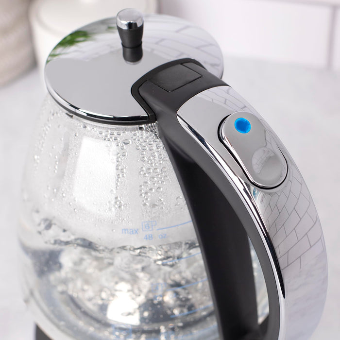 Close up of blue indicator button on a black and polished chrome Capresso 48 oz electric kettle displayed on a white background