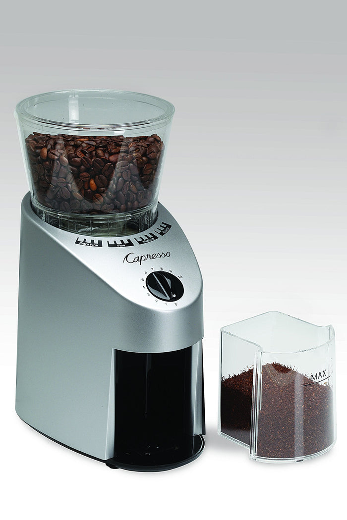 Capresso coffee grinder with ground coffee on a white background