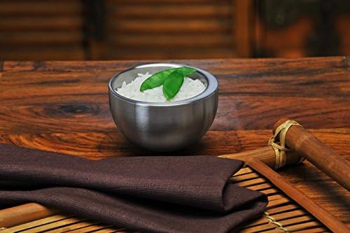 Carl Mertens medium balance sensitive cup with rice inside on a wooden surface next to a table cloth