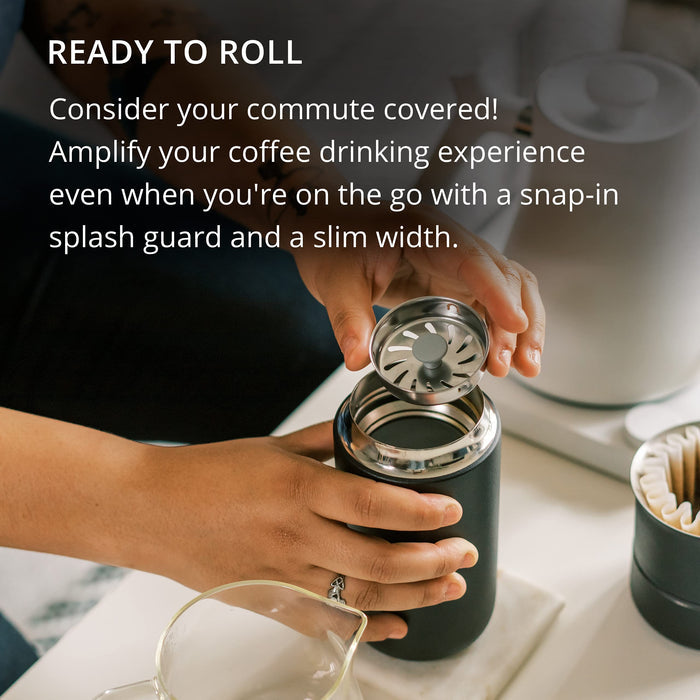 Person holding a black insulated coffee mug with a snap-in splash guard, text about commuting and coffee drinking experience.