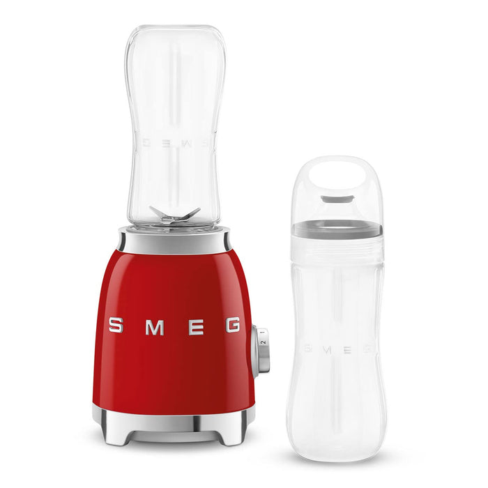 Red Smeg retro line personal blender next to clear tumbler on a white background