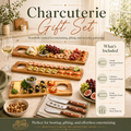 Charcuterie gift set with wooden boards, knives, and food on a table. Including on small, one large and one medium charcuterie board and a 3 piece cheese knife set