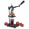 Frieling black Cilio juicer extractor and juice press with a cup full of pomegranate juice and pomegranates while one is being juiced displayed on a white background