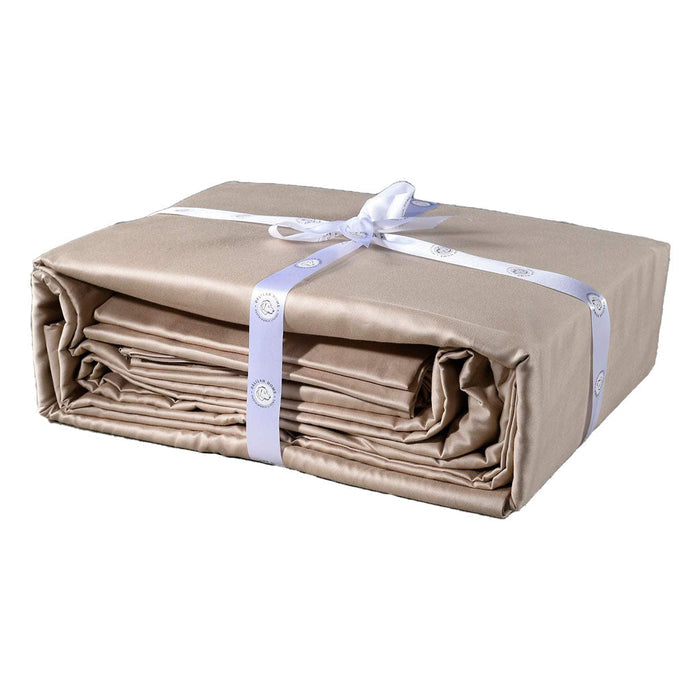A folded beige twin XL Delilah home 100 organic cotton bed sheet set tied with a ribbon, on a white background.