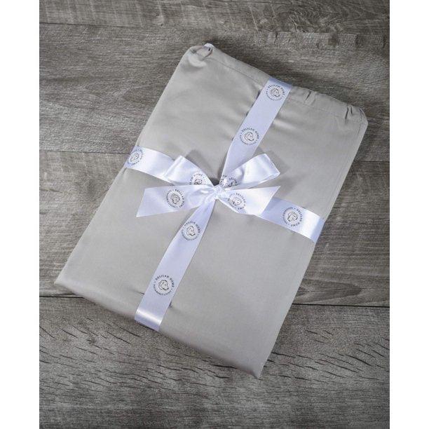Top view of a folded slate gray queen Delilah home 100 organic cotton bed sheet set tied with a ribbon, on a wooden surface.