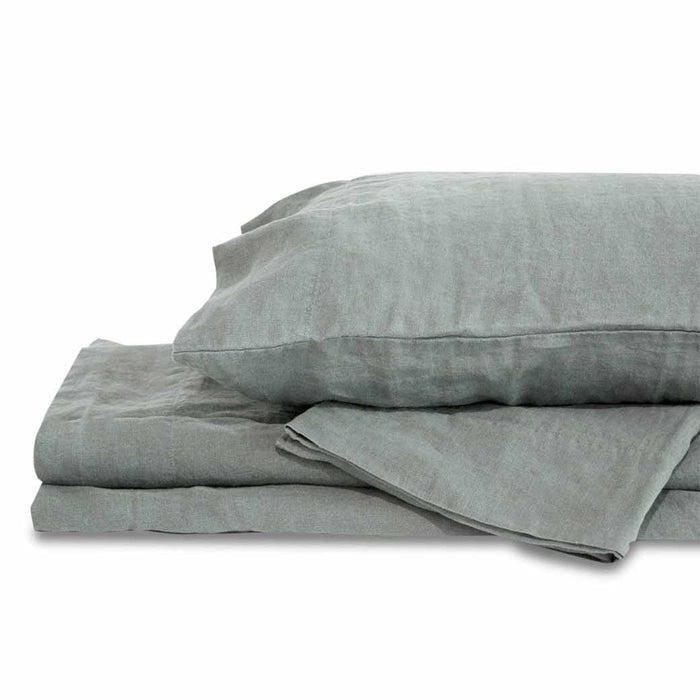 Light gray queen Delilah home 100 organic hemp fitted sheet folded on each other with a pillow on top displayed on a white background