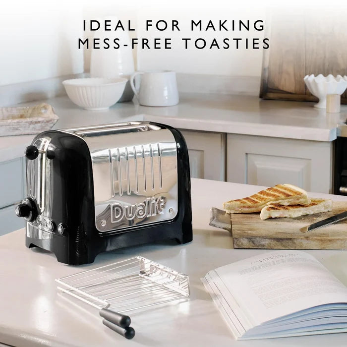 Dualit toaster on a kitchen counter with toast and kitchen items such as a sandwich cage in the background
