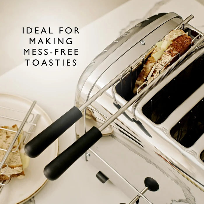A stainless steel 4-slice toaster with black handles shown on a light countertop, with toast inside one slot and a plate of toast partially visible on the left. Text on the image reads 'IDEAL FOR MAKING MESS-FREE TOASTIES'.