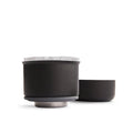 Black coffee dripper with metallic bases on a white background