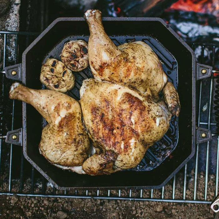 FINEX 12″ Cast Iron Grill Pan on a firepit cooking a chicken