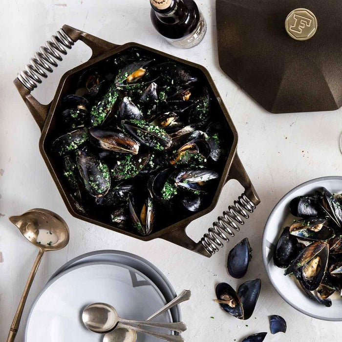 FINEX 5 Qt. Cast Iron Dutch Oven with clams with dinnerware displayed on a white background