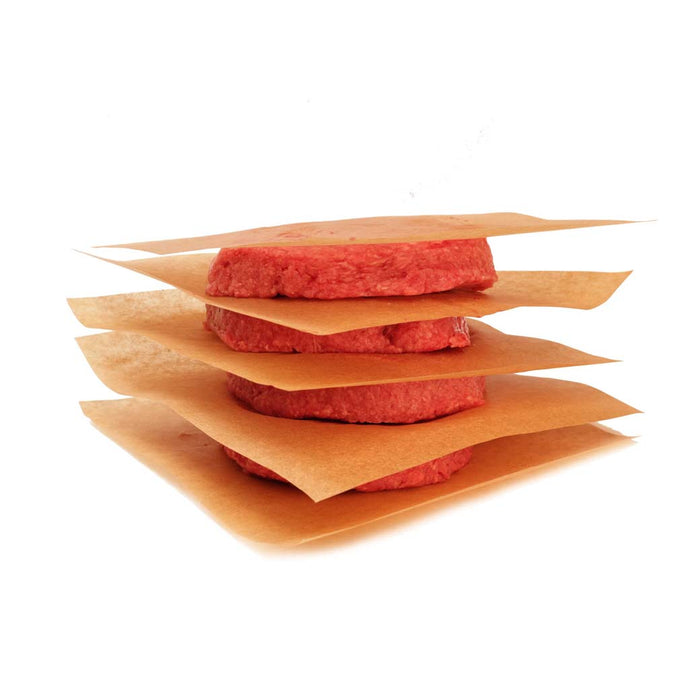 Frieling 6 inch square pre cut freezer baking sheets stacked between patties on a white background