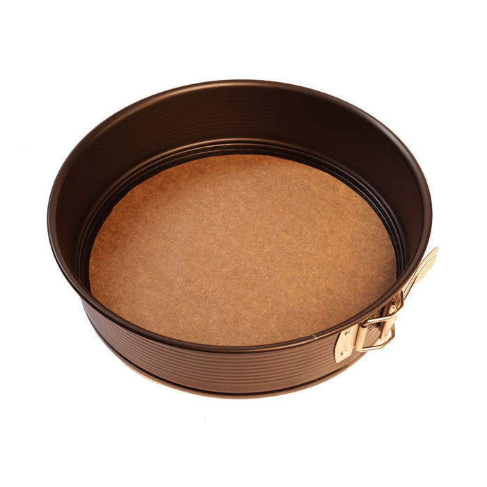 Pre cut round sheet of Frieling unbleached parchment paper with round metal baking ring on top of a parchment paper on a white background