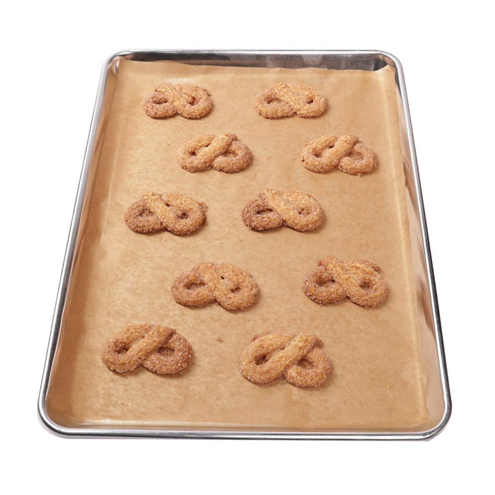 Pretzels placed on Frieling unbleached parchment paper on a baking sheet on a white background