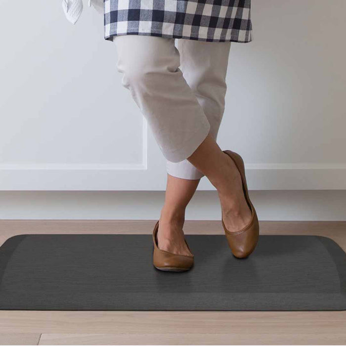 Someone standing on a charcoal mat in a room