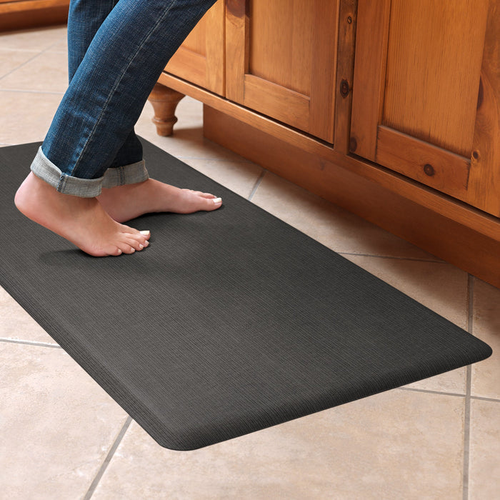 Someone standing on a Gelpro designer comfort anti fatigue kitchen floor mat in a kitchen setting