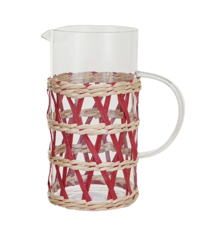Glass pitcher with woven sleeve.