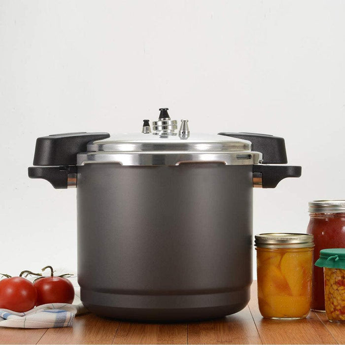 Granite Ware Pressure Canner, Cooker, and Steamer next to tomatoes and canned materials in  jars