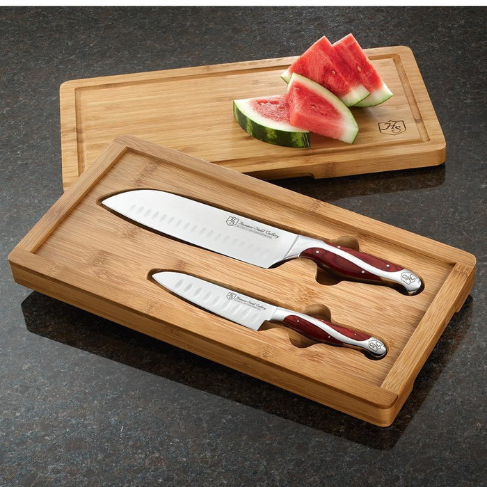 Hammer Stahl 2-Piece Santoku Set with Bamboo Case with the knives inserted into the bamboo case and watermelon sitting on the lid displayed on a dark granite surface