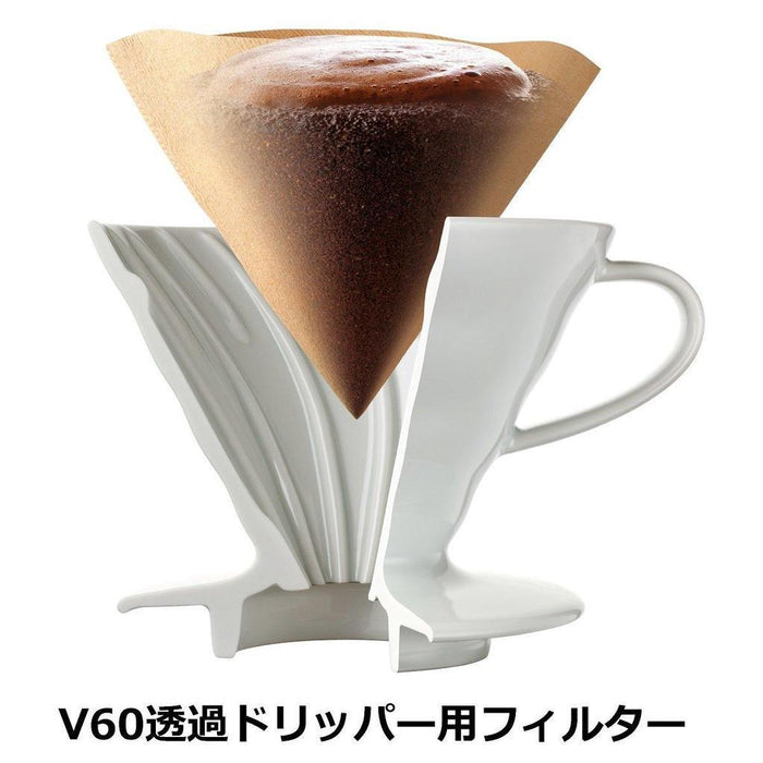 White ceramic Hario dripper with filter and ground coffee inside displayed on a white background