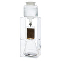 Clear glass coffee maker with a white top making coffee on a white background