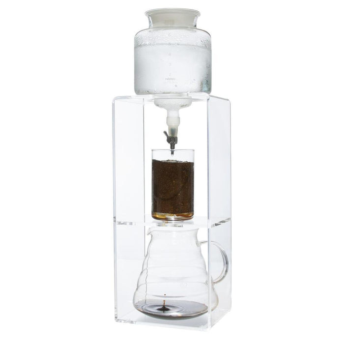 Clear glass coffee maker with a white top making coffee on a white background