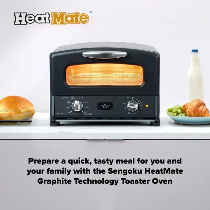 A black HeatMate toaster oven sits on a white countertop with food props and a milk bottle nearby. The oven door is open, showing glowing orange heating elements inside.