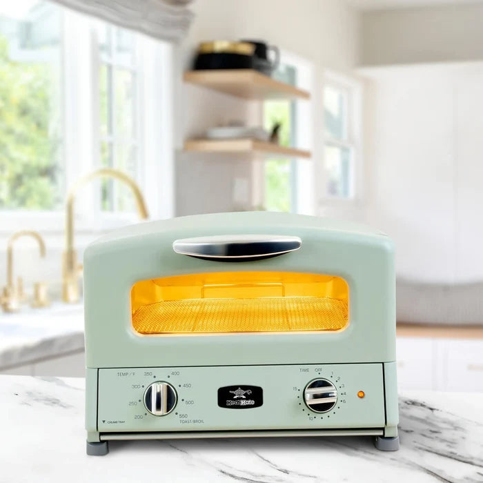 Mint green toaster oven on a kitchen counter with a blurred background