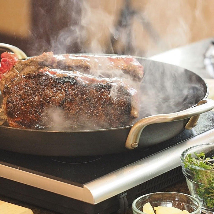 ICON Griddle - 12″ with beef being cooked on top of a portable stovetop