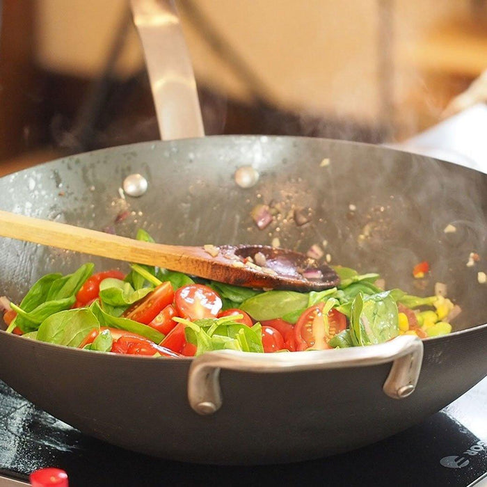 ICON Wok - 14″ with cooked veggies inside and wooden spoon