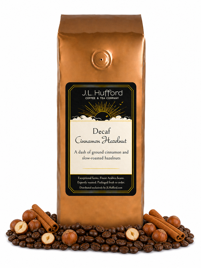 1 lb Decaf Cinnamon Hazelnut coffee beans bag with coffee beans, cinnamon sticks, and hazelnuts in front displayed on a white background