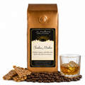 1 lb Funkee Monkee coffee beans bag with coffee beans, toffee bark, and a glass of whiskey in front displayed on a white background