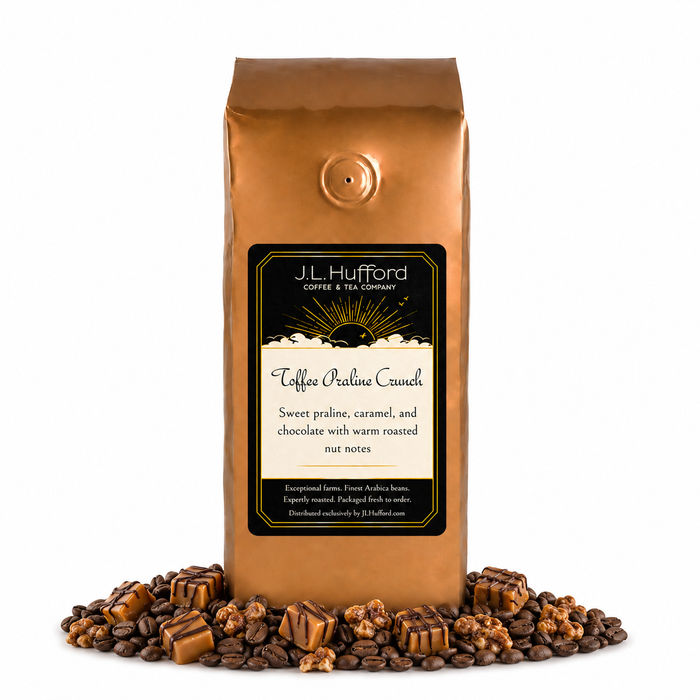 1 lb J.L. Hufford Toffee Praline Crunch coffee bag with coffee beans, praline, and caramel blocks drizzled with chocolate on a white background