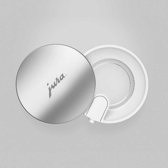 Top view of a Jura 16.9oz glass milk carafe with lid on a white background