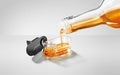 A close-up image of the JURA syrup attachment having syrup being poured into it on a white background