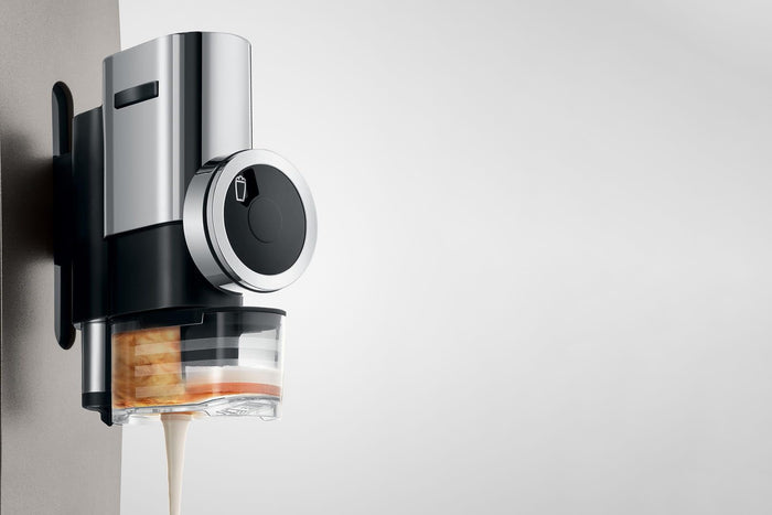 Close up of Jura syrup attachment pouring syrup into a drink on a white background