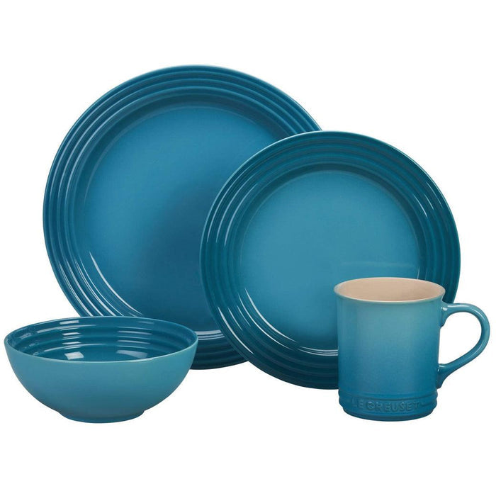 Set of Caribbean Le Creuset bowl, mug, and plates displayed on a white background