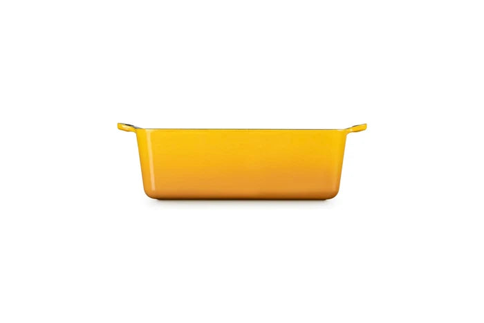 A rectangular yellow baking dish with side handles, shown from a front-facing perspective on a solid white background.