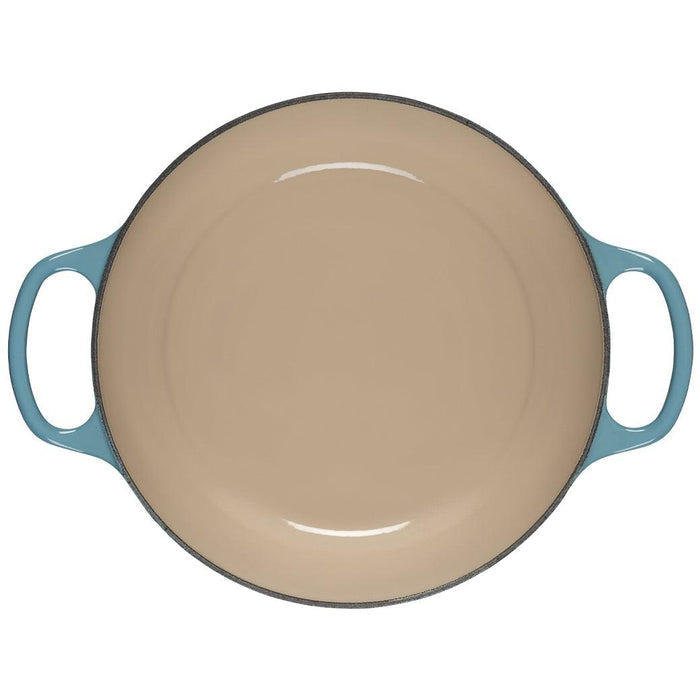 Caribbean 5.25 Qt Deep Le Creuset enameled cast iron Dutch oven without the lid showing the beige interior on a white background