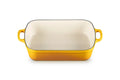A rectangular yellow enameled baking dish with a cream-colored interior and two yellow side handles, shown on a plain white background.