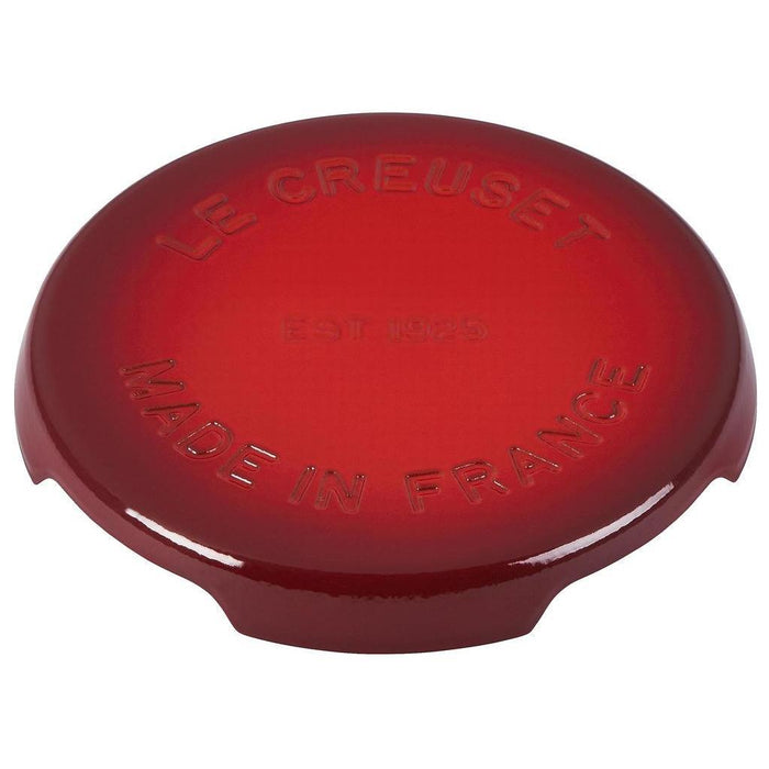 8.8 inch cerise Le Creuset enameled cast iron signature trivet displayed on a white background