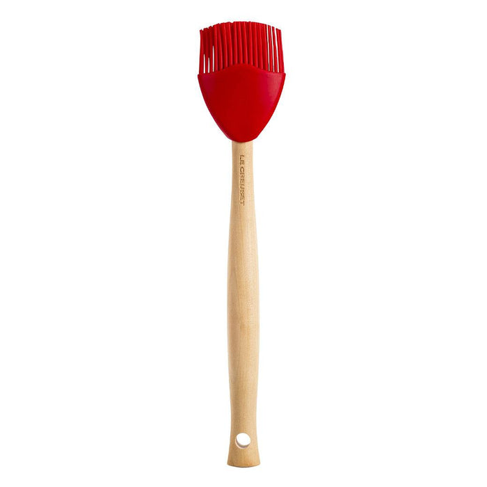 Cerise Le Creuset Craft basting brush displayed vertically on a white background