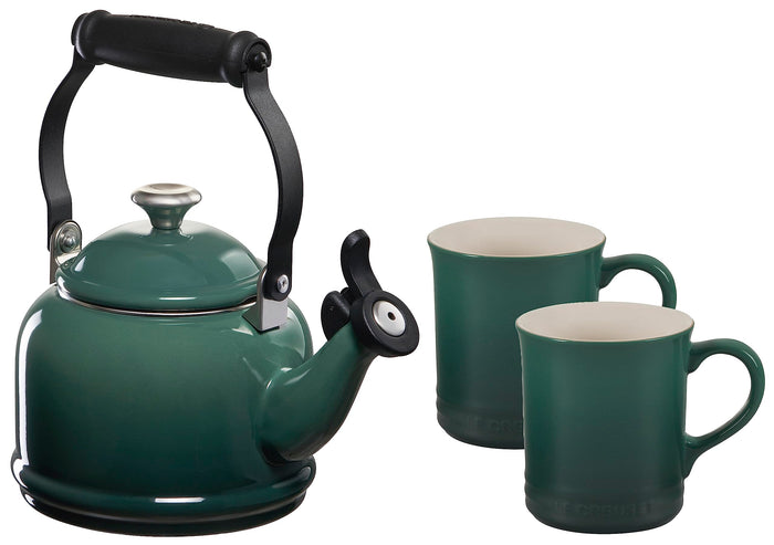 Green teakettle with black handle and two matching green mugs on a white background